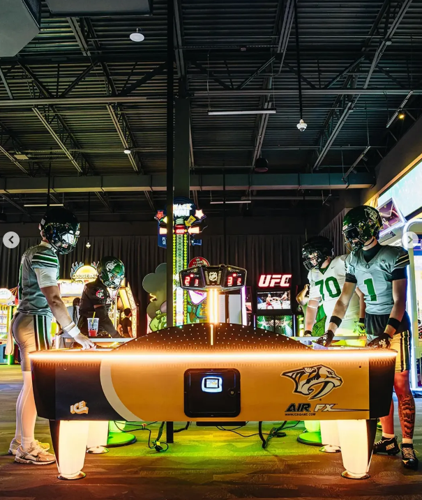Air hockey table standoff in a neon arcade