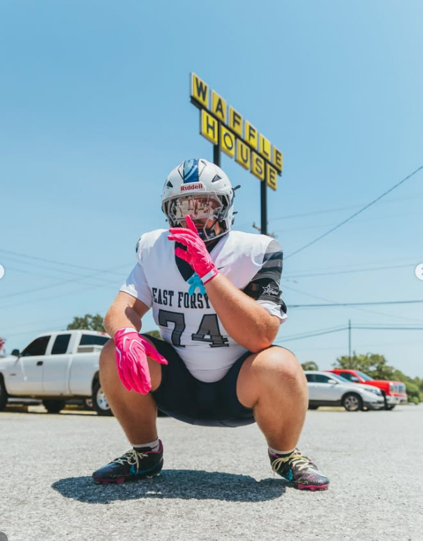 Player crouched under the roadside sign